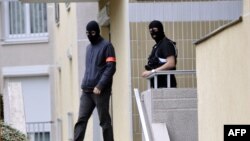 Policemen leave an appartment building, where investigators searched a lock-up garage possibly used by people arrested during an anti-terror operation conducted four days ago, October 10, 2012 in Torcy, east of Paris.