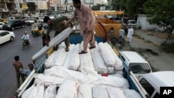 Pakistani volunteers load tents and other relief supplies into a truck to send it for earthquake-affected areas of the Baluchistan province, in Karachi, Pakistan, Sept. 28, 2013.