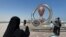 A woman takes a photograph of the FIFA World Cup Qatar 2022 countdown clock in Doha, Qatar, Oct. 17, 2022.