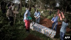 FILE - Health workers prepare to bury a coffin containing a victim of the ebola virus on May 16, 2019 in Butembo, DRC.