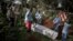FILE - Health workers prepare to bury a coffin containing a victim of the ebola virus on May 16, 2019 in Butembo, DRC.