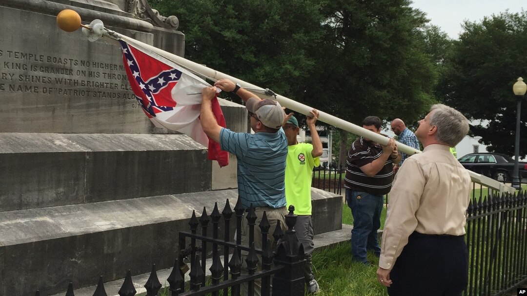 Alabama state workers take down a Confederate flag on the grounds of the state capitol in Montgomery, June 24, 2015.