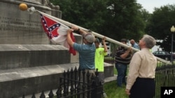 Alabama state workers take down a Confederate flag on the grounds of the state capitol in Montgomery, June 24, 2015.