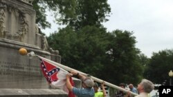 Alabama state workers take down a Confederate flag on the grounds of the state capitol in Montgomery, Alabama, June 24, 2015.