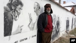 Nikolay, resident of the Staro Zhelezare village poses in front of a mural depicting his own portrait next to Pope Francis in the Bulgarian village of Staro Zhelezare, Jan. 27, 2016.