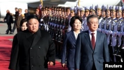 Presiden Korea Selatan, Moon Jae-in dan pemimpin Korea Utara, Kim Jong-un berjalan bersama di bandara dekat Gunung Paektu, Korea Utara, 20 September 2018.