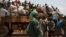 FILE - A woman looks on as people on a truck gather their belongings during a road repatriation to Chad in the capital Bangui, January 22, 2014. 