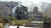 People drive next to a building, targeted in an Israeli airstrike the night before, in Beirut's southern suburbs on Oct. 20, 2024.