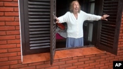 Una mujer mira desde su casa hacia la calle inundada después de una tormenta en Bahía Blanca, Argentina, el viernes 7 de marzo de 2025.