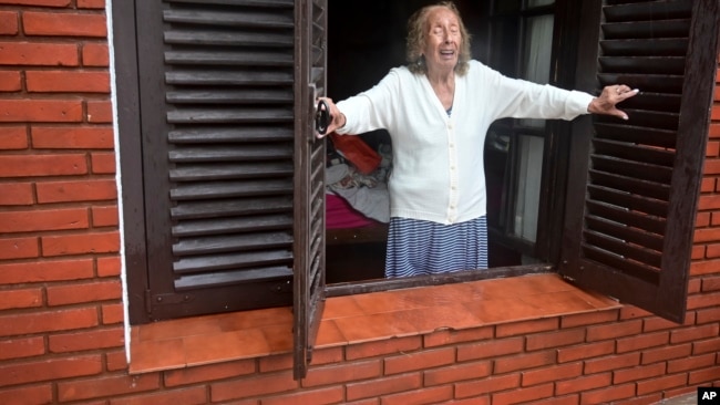 Una mujer mira desde su casa hacia la calle inundada después de una tormenta en Bahía Blanca, Argentina, el viernes 7 de marzo de 2025. (Foto AP/Juan Sebastián Lobos).