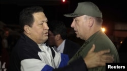 Presiden Venezuela Hugo Chavez (kiri) disambut oleh Menteri Pertahanan Venezuela Admiral Diego Molero, setibanya di bandara Simon Bolivar, Caracas dari pengobatan selama 10 hari di Kuba (7/12). 