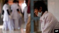 A tuberculosis patient Manjeet Mishra, 18, sits outside a ward at Lal Bahadur Shastri Government Hospital at Ram Nagar in Varanasi, India, Feb. 3, 2014.