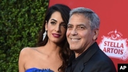 En esta foto de archivo del 22 de octubre de 2017, Amal Clooney y George Clooney llegan al estreno de "Suburbicon" en Los Ángeles. George y Amal Clooney están donando $ 500,000 a estudiantes que organizan marchas a nivel nacional contra la violencia con armas de fuego, y dicen que también asistirán a las protestas planeadas el próximo mes. 