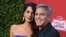 En esta foto de archivo del 22 de octubre de 2017, Amal Clooney y George Clooney llegan al estreno de "Suburbicon" en Los Ángeles. George y Amal Clooney están donando $ 500,000 a estudiantes que organizan marchas a nivel nacional contra la violencia con armas de fuego, y dicen que también asistirán a las protestas planeadas el próximo mes. 