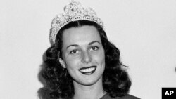 FILE - Miss America Bess Myerson, center, poses at the annual beauty pageant held at Atlantic City, New Jersey, Sept. 8, 1945.