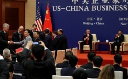 FILE - China's President Xi Jinping and U.S. President Donald Trump witness U.S. and Chinese business leaders signing trade deals at the Great Hall of the People in Beijing, China, Nov. 9, 2017.