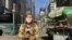  La periodista Celia Mendoza, de la Voz de América, graba un reportaje en el centro de Nueva York, en la esquina entre la Calle 34 y la 8ª Avenida, tras entrevistar a vendedores ambulantes.