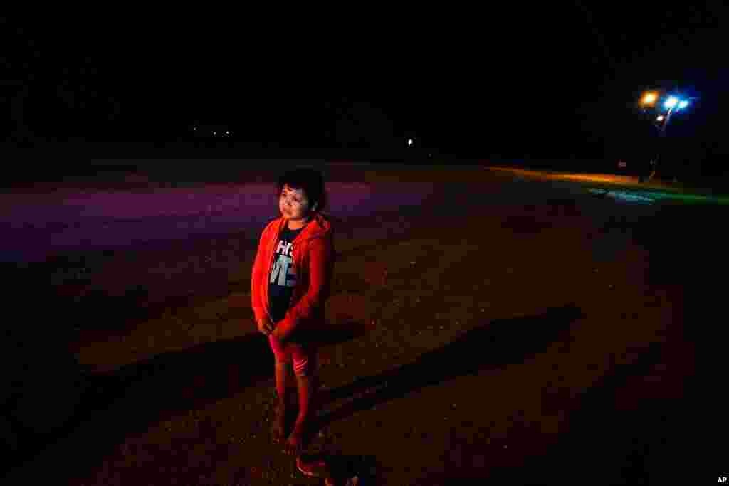 Emely, 8, of Honduras, stands alone after turning herself in upon crossing the U.S.-Mexico border, in La Joya, Texas. The unaccompanied child cried as she told her story of losing her guides and walking for miles with another group. 