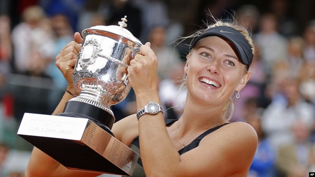 Petenis Rusia, Maria Sharapova memegang trophy juara Perancis Terbuka setelah mengalahkan petenis Italia, Sara Errani, Sabtu (9/6).
