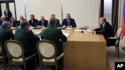Russian President Vladimir Putin (R) chairs a meeting with the top military brass on military issues in Sochi, Russia, May 17, 2018. 