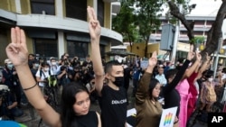 Anti-government protesters raise a three-finger salute, a resistance symbol borrowed by Thailand's anti-coup movement from the Hollywood movie 'The Hunger Games,' during a protest in front of Democracy Monument in Bangkok, Thailand, Aug, 7, 2020.