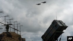 Архівне фото. Винищувачі F-16 Повітряних Сил України пролітають над системою ППО Patriot у неоголошеній локації, 4 серпня 2024. AP Photo/Efrem Lukatsky