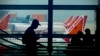 FILE - A man is silhouetted against an airport window with Air India planes parked in the background in New Delhi, Oct. 31, 2023.