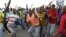 Striking miners dance and cheer after they were informed of a 22 percent wage increase offer outside Lonmin's Marikana mine, 100 km (60 miles) northwest of Johannesburg, September 18, 2012. 