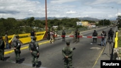 La Guardia Nacional de Venezuela (abajo) parada frente a soldados colombianos en el puente internacional Simón Bolívar, en Cúcuta, Colombia. Foto de archivo.