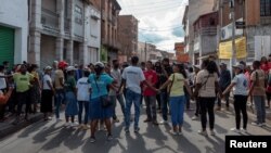 FILE - People stand along a street before riot police officers fired tear gas canisters to disperse supporters of Madagascar's opposition member and presidential candidate Jean Jacques Ratsietison attending his political rally, in Antananarivo, Madagascar November 4, 2023.