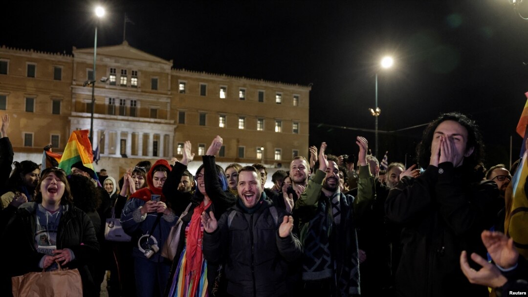 Pripadnici LGBTQ zajednice u Grčkoj i njihovi prijatelji slave ispred zgrade parlamenta u Atini posle usvajanja predloga zakona o istopolninm brakovima, 15. februara 2024. (Foto: REUTERS/Louisa Gouliamaki)