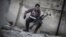 In this Friday, Jan. 18, 2013 photo, a sniper takes position on a roof during combat in the neighborhood of Saif Al-Dawlah in Aleppo, Syria. 