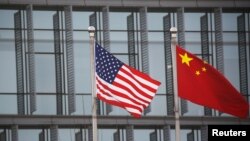 Bendera AS dan China berkibar di luar sebuah perusahaan Amerika di Beijing, China, 21 Januari 2021. (Foto: Reuters)