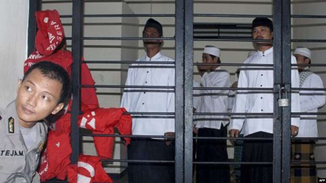 Indonesian Muslims who are on trial for their involvement in a fatal attack against followers of a minority Islamic sect earlier this year wait for the start of the hearing at a district court in Serang, Banten province, Indonesia, July 28, 2011