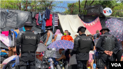 Policías nicaragüenses custodian al grupo de migrantes en la frontera con Costa Rica.