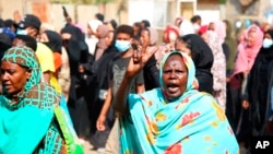 FILE - A pro-democracy protester flashes the victory sign as thousands take to the streets to condemn a takeover by military officials, in Khartoum, Sudan, Oct. 25, 2021. 