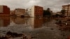 Edificios se reflejan en el agua fangosa tras las catastróficas inundaciones, mientras España se prepara para más lluvias torrenciales, en Paiporta, Valencia, España, el 13 de noviembre de 2024. (REUTERS/Vincent West)