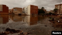 Edificios se reflejan en el agua fangosa tras las catastróficas inundaciones, mientras España se prepara para más lluvias torrenciales, en Paiporta, Valencia, España, el 13 de noviembre de 2024. (REUTERS/Vincent West)