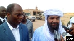 FILE: Ansar Dine Islamist group leader Iyad Ag Ghaly (R) speaks next to Burkina Faso's then-Foreign Minister Djibrille Bassole (L) on August 7, 2012 at the Kidal airport, northern Mali. 