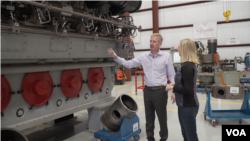 Fairbanks Morse Defense CEO George Whittier shows VOA Pentagon correspondent Carla Babb one of the engines built for an amphibious warfare ship at the company's service center in Norfolk, Virginia. (Mary Cieslak/VOA)