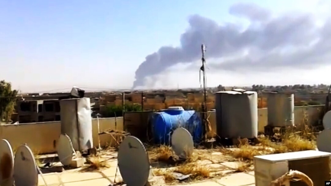 Una columna de humo se eleva de la refiner[ia de Beiji, al norte de Bagdad.