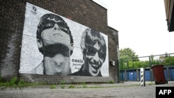 Lukisan mural Liam dan Noel Gallagher, anggota band Oasis menghiasi dinding toko musik Sifters Record di Burnage, pinggiran Kota Manchester, di utara Inggris, 27 Agustus 2024. (Foto: Paul Ellis/AFP)