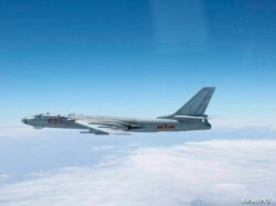 Un avión militar chino bombardero H-6 vuela a través del espacio aéreo entre la isla principal de la prefectura de Okinawa y la pequeña isla Miyako en el sur de Japón, foto tomada el 27 de octubre de 2013.