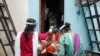 အိန္ဒိယနိုင်ငံ မွမ်ဘိုင်းမြို့မှာ ဒေသခံတွေကို ကိုယ်အပူချိန် တိုင်းတာပေးနေတဲ့ ကျန်းမာရေးဝန်ထမ်းအချို့။ (သြဂုတ် ၁၆၊ ၂၀၂၀)