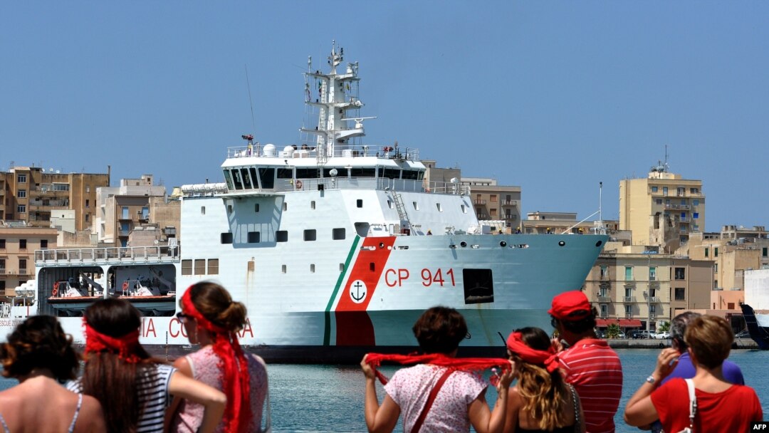 Anggota gerakan T-shirt merah menunggu kedatangan kapal penjaga pantai Diciotti Italia yang membawa 67 pencari suaka, di pelabuhan Trapani, 12 Juli 2018. (Foto: dok).