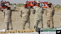 Iranian police officers stand behind narcotic drugs which were seized at border of Iran and Afghanistan, a known drug trafficking route, at the Milak border in southeastern Iran.