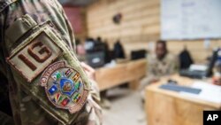 FILE - In this photo taken Feb. 24, 2018 and released by the U.S. Air Force, Tech. Sgt. Starr Day talks with service members during a battlefield circulation site visit at Camp Simba, Manda Bay, Kenya. 