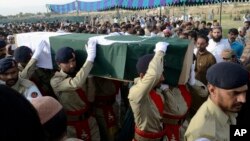 Pakistani troops carry the casket, wrapped in national flag, of provincial candidate Siraj Raisani, who was killed in the Friday's suicide bombing in Mastung, during a funeral prayer in Quetta, Pakistan, July 14, 2018. 