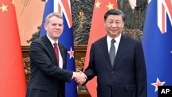 在新华社发布的这张照片中，新西兰总理克里斯·希普金斯(左)于2023年6月27日星期二在北京人民大会堂与中国国家主席习近平握手 。
(Shen Hong/Xinhua via AP)