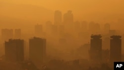 FILE - General view of the city during a sunset as smog covers Sarajevo, Bosnia, Nov. 14, 2022. 